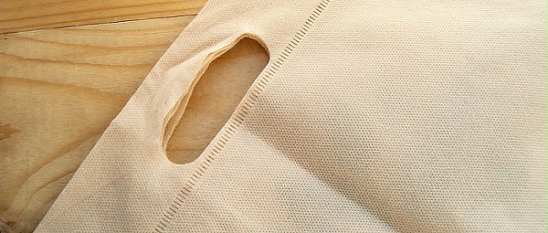 千库网_放弃塑料袋的概念，无纺布生态袋，平铺在浅色木质背景上，顶视图，复制空间_摄影图编号14950906